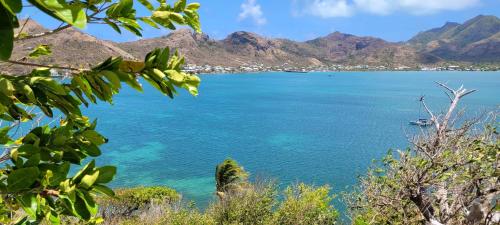 a view of the ocean with mountains in the background at Colorful Garden House in Providencia
