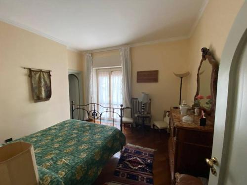 1 dormitorio con cama, mesa y ventana en B&G large and bright apartment en Cava deʼ Tirreni