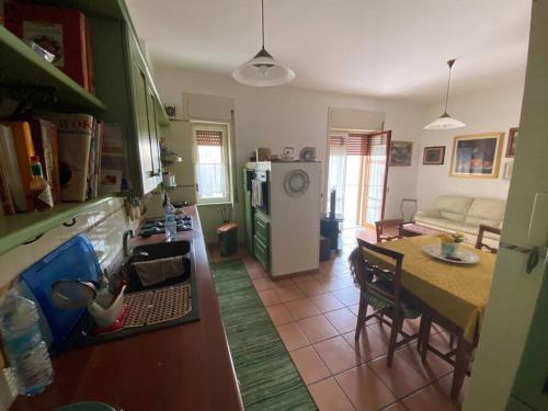 cocina y sala de estar con mesa y nevera en B&G large and bright apartment en Cava deʼ Tirreni