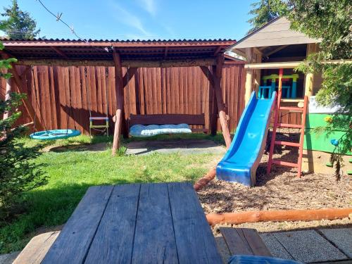 a playground with a slide in a backyard at Oázis Vendégház és Appartman in Szilvásvárad