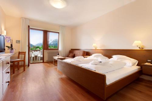 a bedroom with a large bed with white sheets at Hotel Walder in Schenna