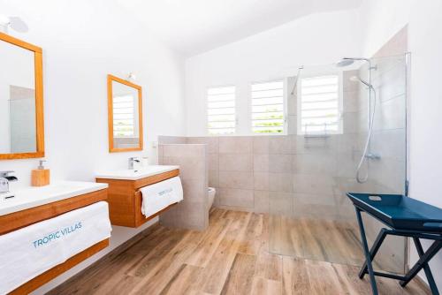 uma casa de banho com um chuveiro, um lavatório e um WC. em Grande villa, vue 360° sur lagon em Le François