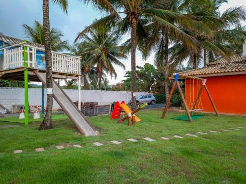 a park with a playground with a slide and palm trees at Eden One in Ilhéus