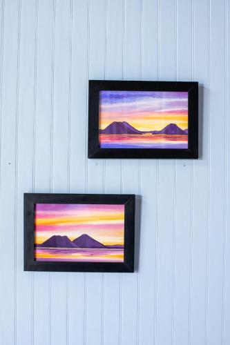 two framed paintings of a sunset on a wall at La Bonita at Los Elementos in Santa Cruz La Laguna