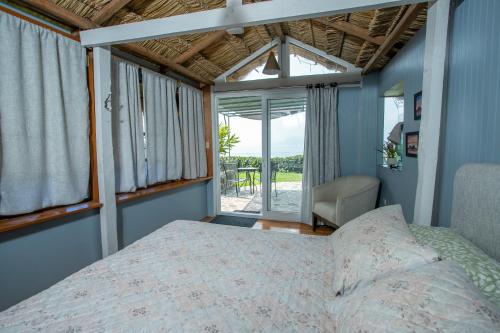 a bedroom with a bed and a large window at Los Elementos in Santa Cruz La Laguna