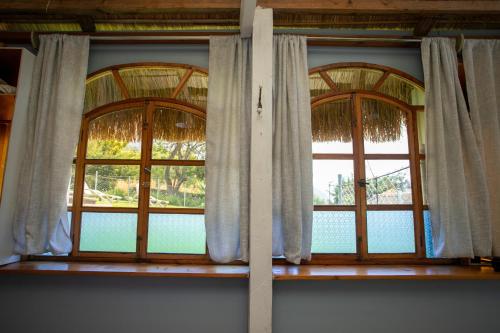 two windows in a room with curtains on them at La Bonita at Los Elementos in Santa Cruz La Laguna