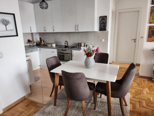 uma cozinha com uma mesa com cadeiras e um vaso de flores em ONE bedroom apartment - close the CITY CENTER! PRISHTINA em Pristina