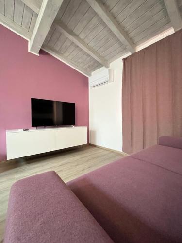 a room with two beds and a flat screen tv at Casa Margheritina in Malcesine