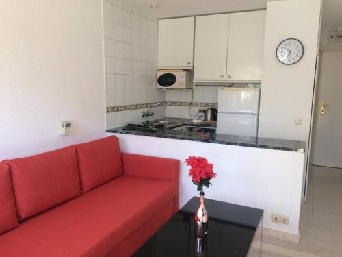 un divano rosso in una cucina bianca con bancone di Estudio vacaciones en los álamos a Torremolinos