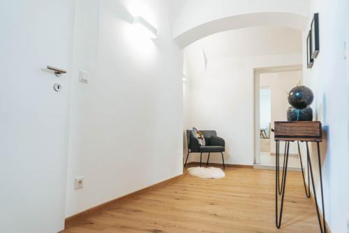 a living room with a table and a chair at Apartment an der Rugenstiege in Steiner Altstadt in Krems an der Donau