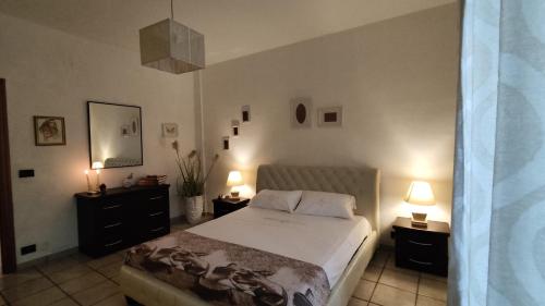 a bedroom with a bed with two night stands and two lamps at Maison Lido Silvana in Pulsano