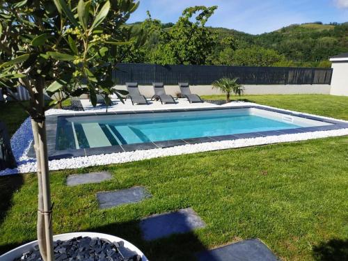 uma piscina com espreguiçadeiras num quintal em CHAMBRE & SDB PRIVÉE avec piscine en bord de Via Rhona em Sarras
