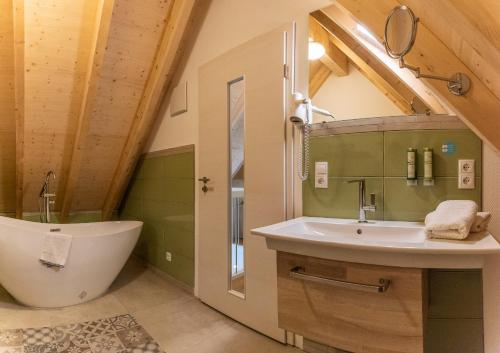 a bathroom with a sink and a tub and a toilet at Struck Landhotel & SPA in Attendorn