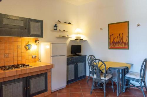 una cucina con un tavolo e un frigorifero bianco di La Casetta di Sara a Lampedusa