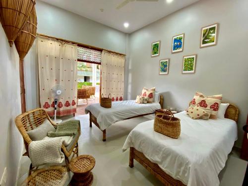 sypialnia z 2 łóżkami i krzesłem w obiekcie Jetuka Villa - Sibsagar w mieście Sibsāgar