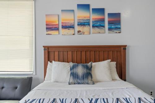 a bedroom with a bed with four paintings on the wall at Mt Royal Motel in Old Orchard Beach