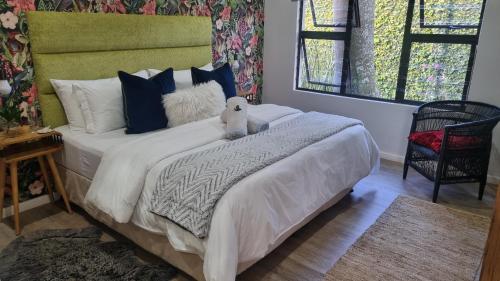 a bedroom with a bed with a teddy bear on it at Kingsley House Chalet in Ballito