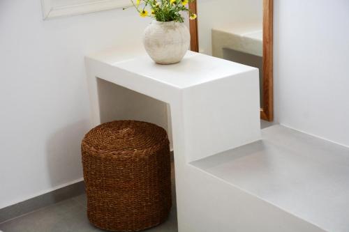a vase on a white table with a trash can at Akrotiri in Analipsi