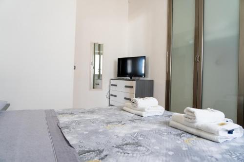 um quarto com uma cama grande e toalhas em Casarossa em Pachino