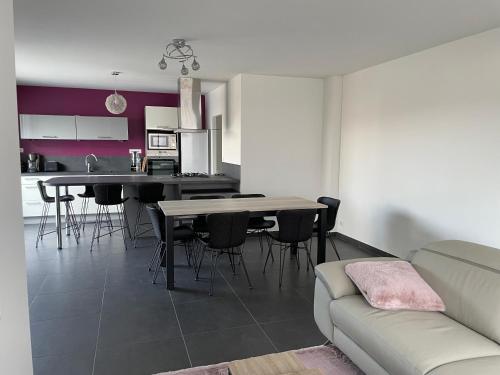 ein Wohnzimmer und eine Küche mit einem Tisch und Stühlen in der Unterkunft La Villa des Amarelles à Pornic - labellisée 3* in Pornic