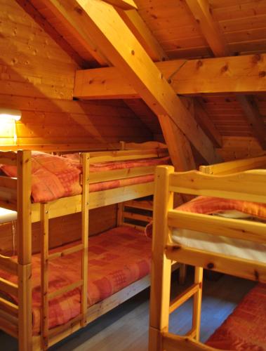 a room with three bunk beds in a wooden attic at CHALET REROLLE in Doucy