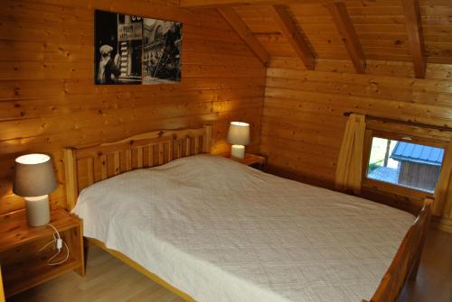 a bedroom with a bed in a log cabin at CHALET REROLLE in Doucy