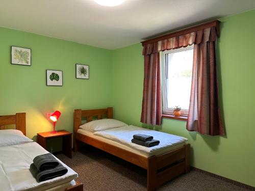 1 dormitorio con 2 camas individuales y ventana en Ubytování Smrk, en Nové Město pod Smrkem