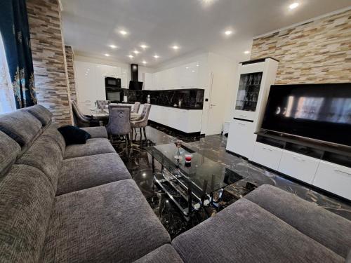 a living room with a couch and a large television at Apartment Monaco in Rijeka