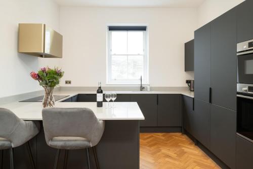 a kitchen with black cabinets and a white counter top at Luxury home by the harbour in Ilfracombe