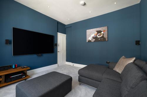 a living room with a couch and a flat screen tv at Luxury home by the harbour in Ilfracombe
