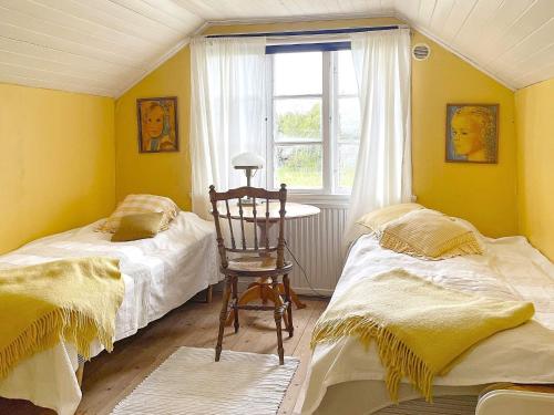 1 dormitorio con 2 camas, mesa y ventana en Holiday home LIDKÖPING X, en Tallbacken
