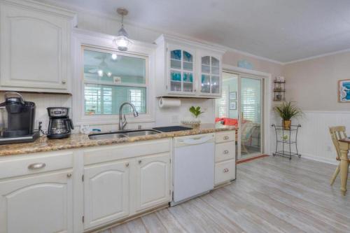 a kitchen with white cabinets and a counter top at Hidden Treasure in Oak Island