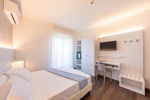 a hotel room with a bed and a desk at Hotel Corfù in Pineto