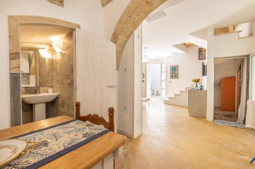 Habitación con mesa, lavabo y pasillo. en Dimora il Castello, en Racale