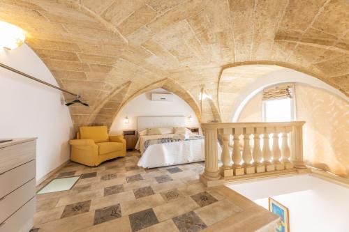 Un dormitorio con una cama y una silla amarilla. en Dimora il Castello, en Racale
