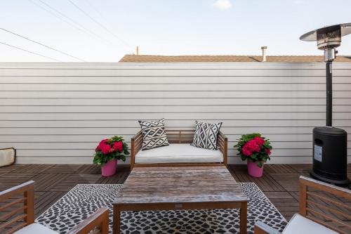 a patio with a couch and a table and flowers at Serenity in the Marigny in New Orleans