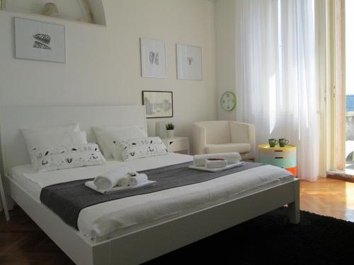 Un dormitorio blanco con una cama grande con toallas. en St. Lazarus Room en Dubrovnik