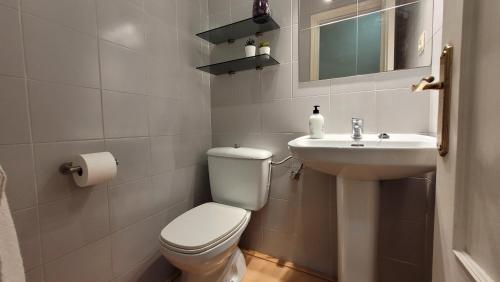een witte badkamer met een toilet en een wastafel bij El encanto de Aguadulce in Aguadulce