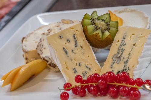 a white plate with cheese and fruit on it at Struck Landhotel & SPA in Attendorn