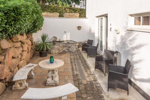a patio with chairs and a table and a stone wall at Struck Landhotel & SPA in Attendorn