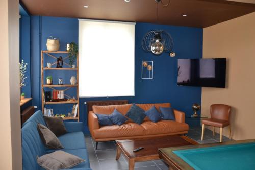 un salon avec un canapé et une télévision dans l'établissement L'Auberge de Vauclair, à Bouconville-Vauclair