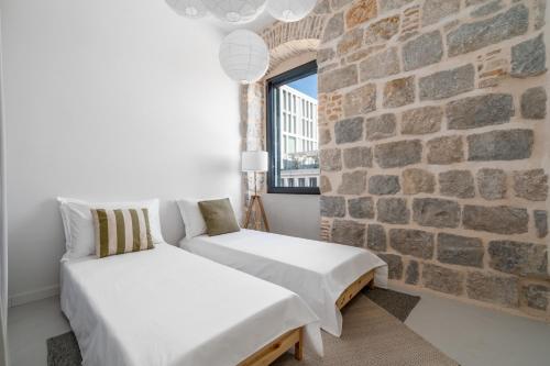 Zimmer mit 2 Betten und Ziegelwand in der Unterkunft Architect's seafront flat in Split