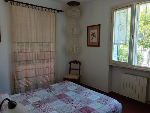a bedroom with a bed and a window and a chandelier at Villetta con giardino a due passi dal mare in Imperia