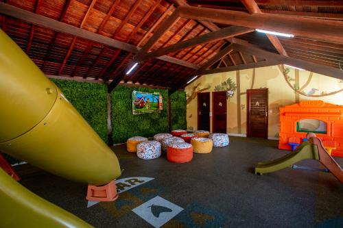 uma sala com um parque infantil com escorrega e equipamento de brincar em Ocaporã Hotel All Inclusive em Porto de Galinhas