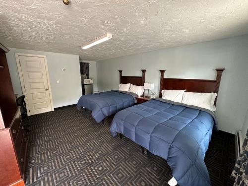 two beds in a hotel room with blue sheets at Redfox Motel in Foxborough