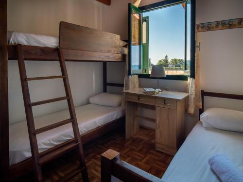 a room with bunk beds and a desk and a window at Mayia Sunset sea front house Gouves Heraklion in Gouves