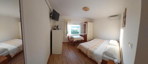 Cette petite chambre comprend 2 lits et une fenêtre. dans l'établissement Gvačić House, à Supetarska Draga