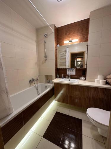 ein Badezimmer mit einer Badewanne, einem Waschbecken und einem WC in der Unterkunft Comfort Zone Ostroda BOHO SCANDI in Ostróda