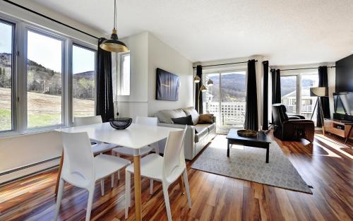 a living room with a white table and chairs at 26#52 Chemin du Hameau (studio) in Stoneham