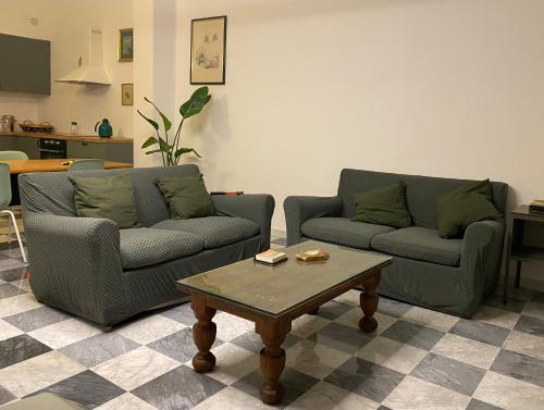 ein Wohnzimmer mit 2 Sofas und einem Couchtisch in der Unterkunft Lo Studio in Pisa
